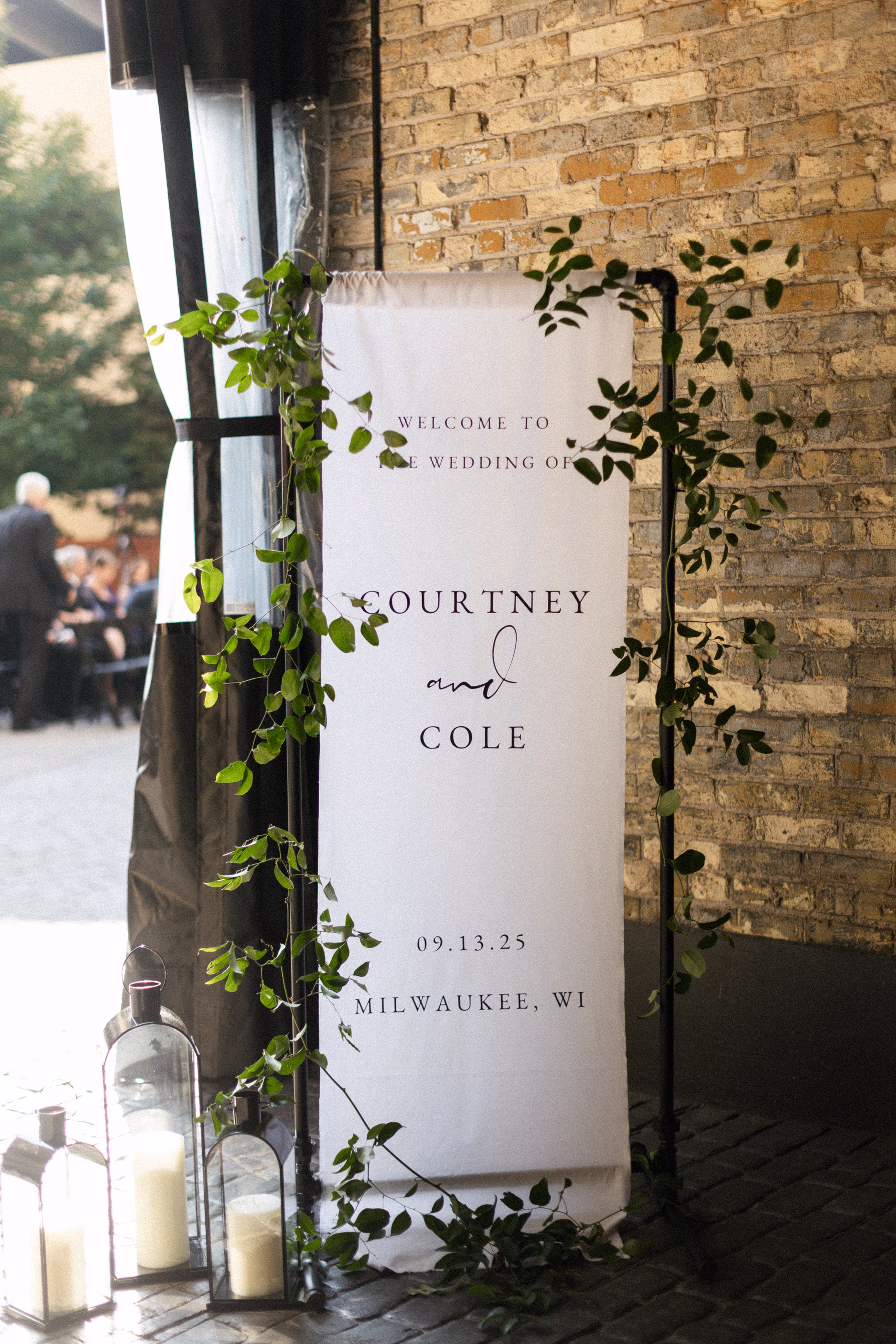 a linen welcome sign for the couple, displayed alongside candles and crawling greenery
