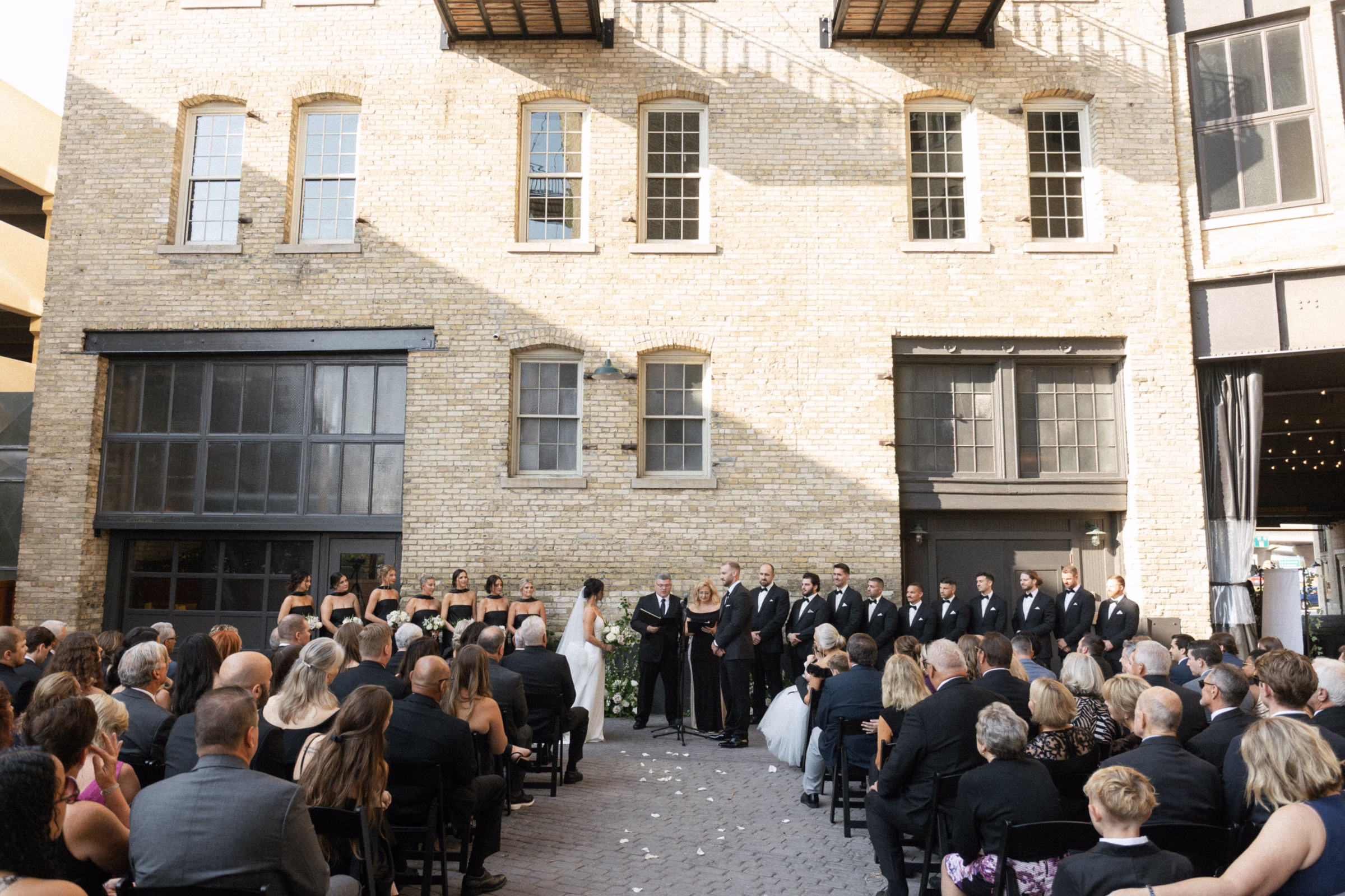 an outdoor wedding ceremony set against a natural brick backdrop in Milwaukee, Wisconsin