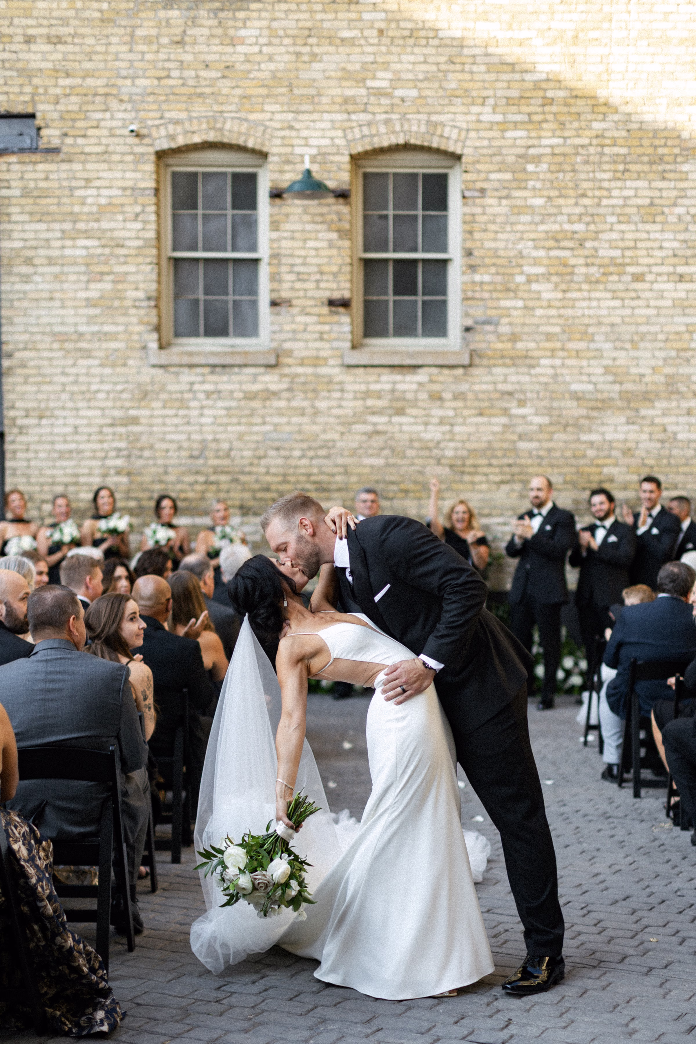 the bride and groom share a kiss after their wedding ceremony