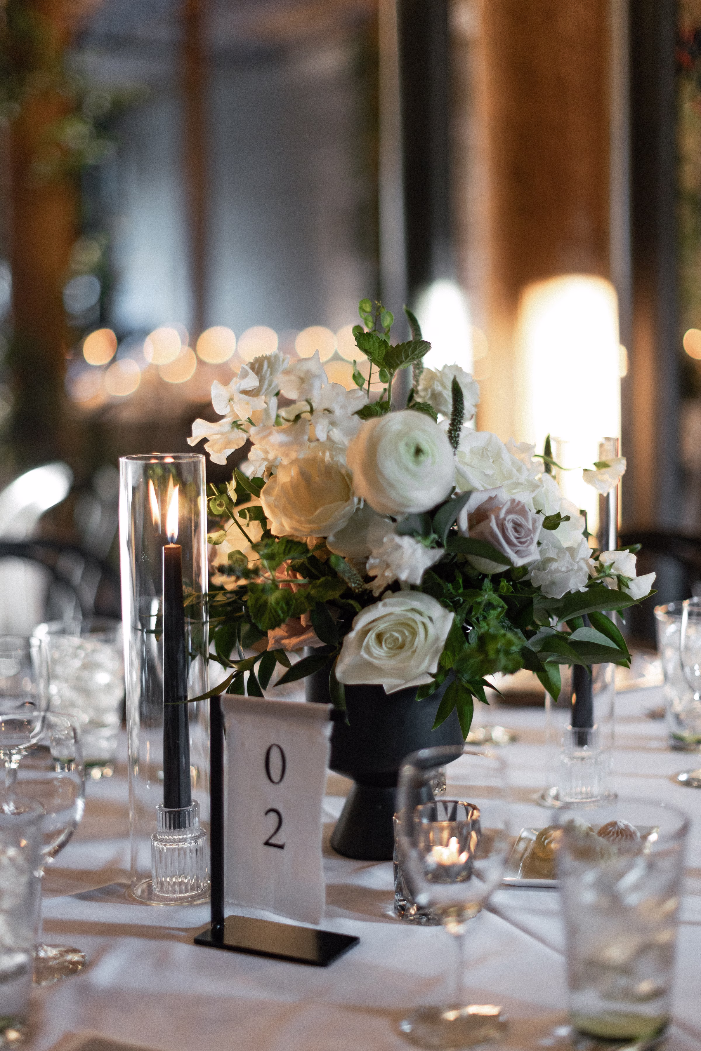 a linen table number displayed alongside a floral centerpiece
