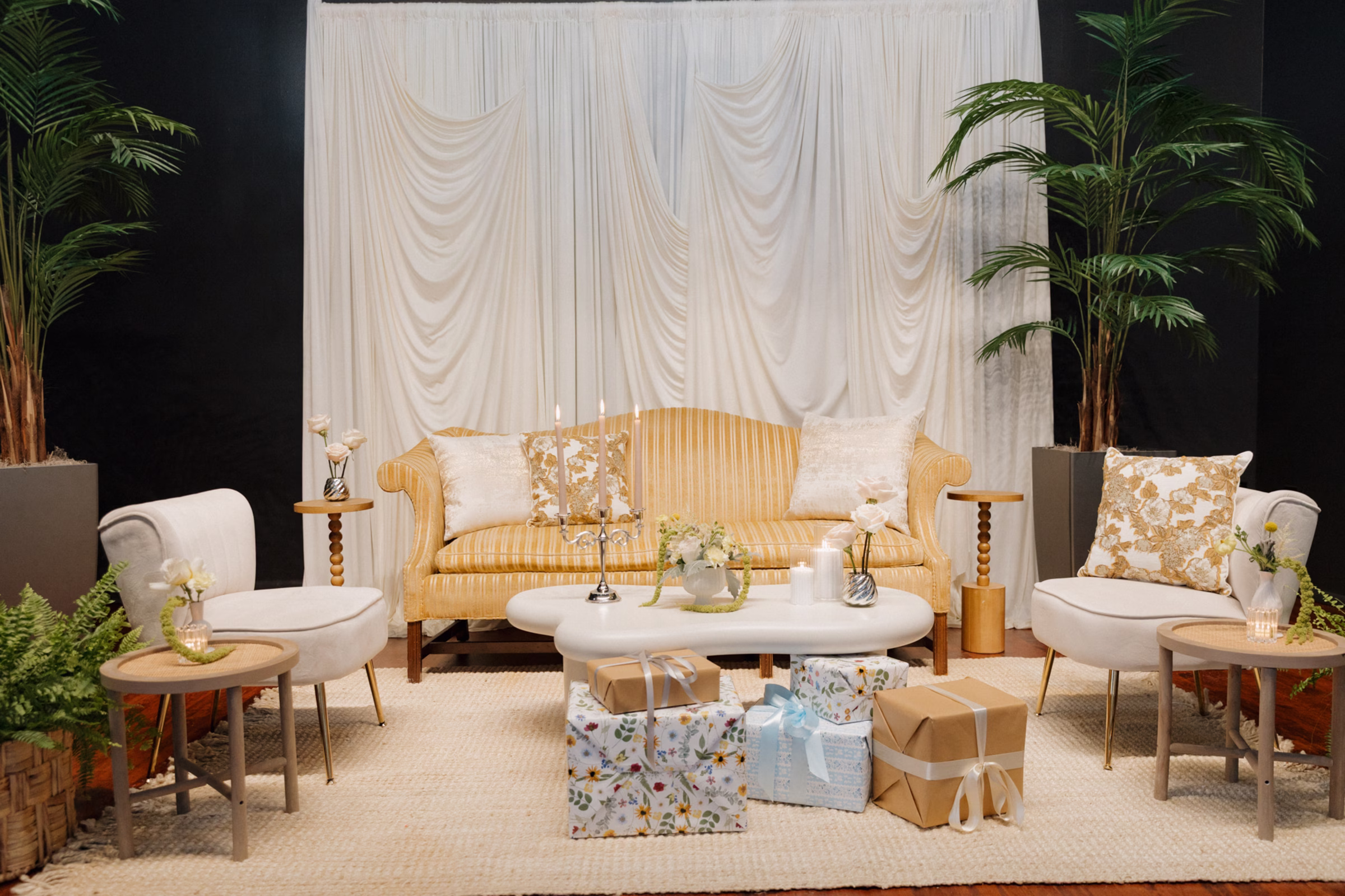 lounge furniture and decor from Adorn Event Company sits on stage at The Fitzgerald, making a cozy space for the bride to open presents