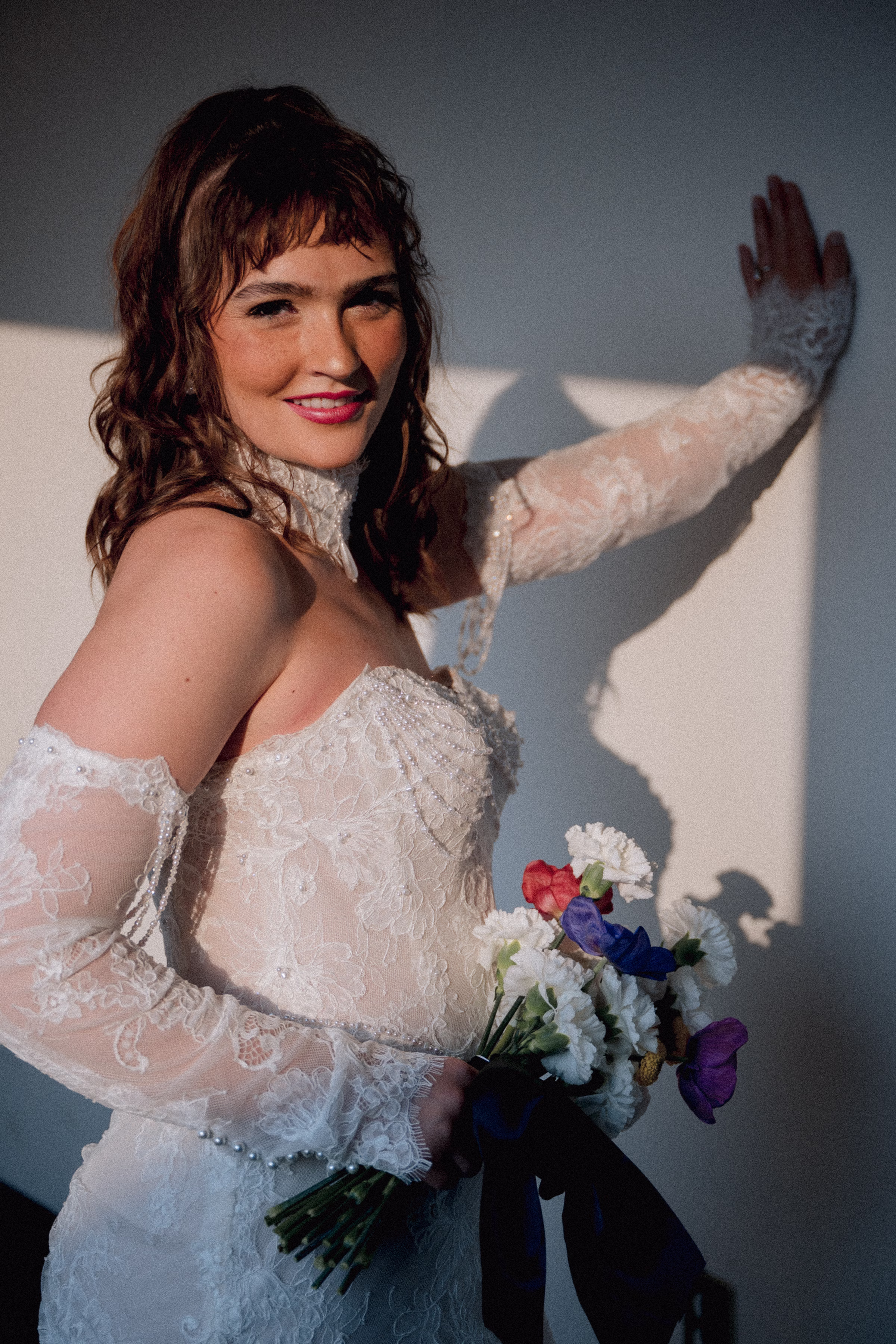 a bride model poses at Jan Serr Studio wearing a gown from Miss Ruby Bridal, with hair and makeup from Beauty Unveiled Agency