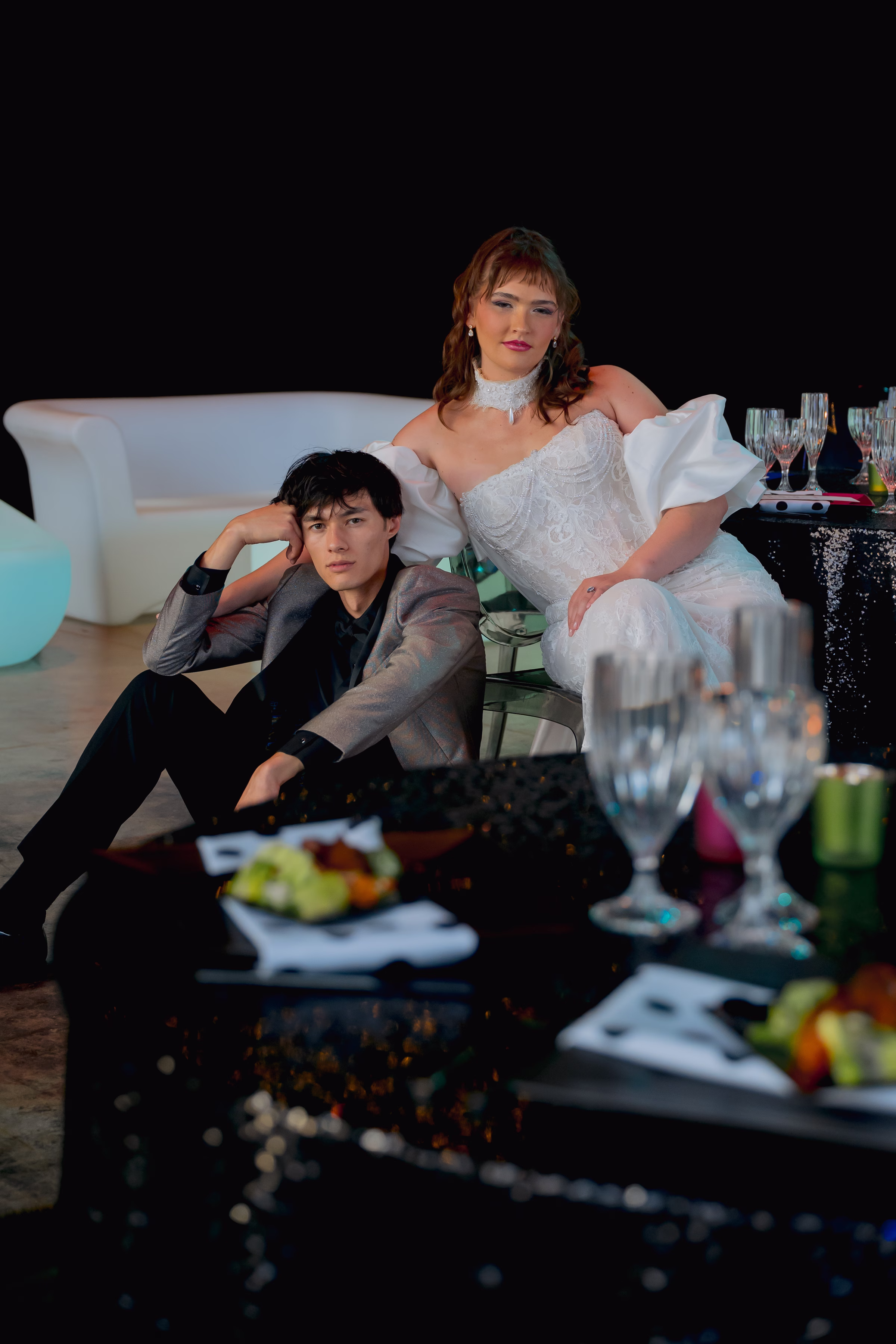 a bride and groom lounge near a reception table at Jan Serr Studio with food from Saz's Catering set on the table