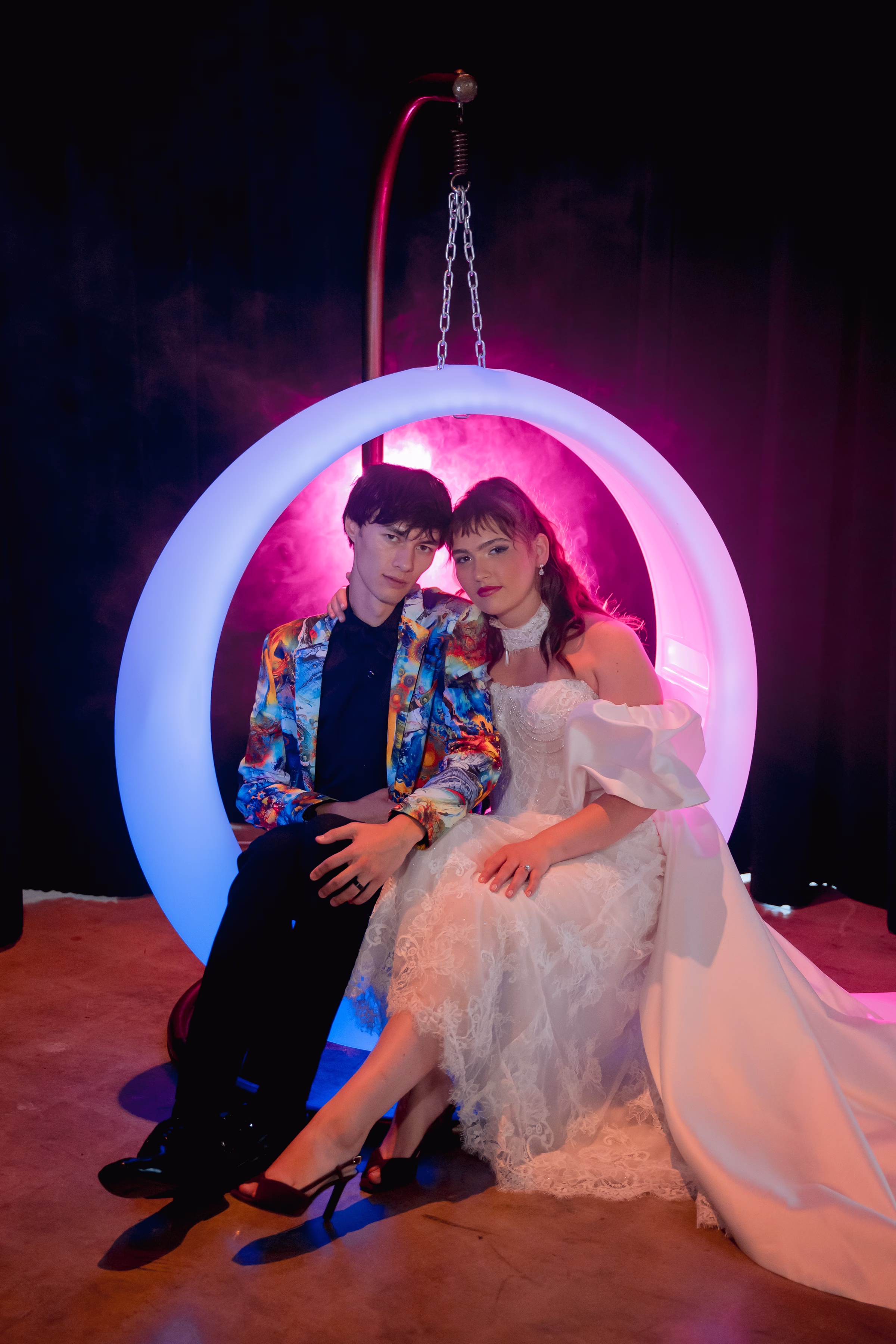 bride and groom models sit in an LED ring-shaped swing set from Record-A-Hit Entertainment