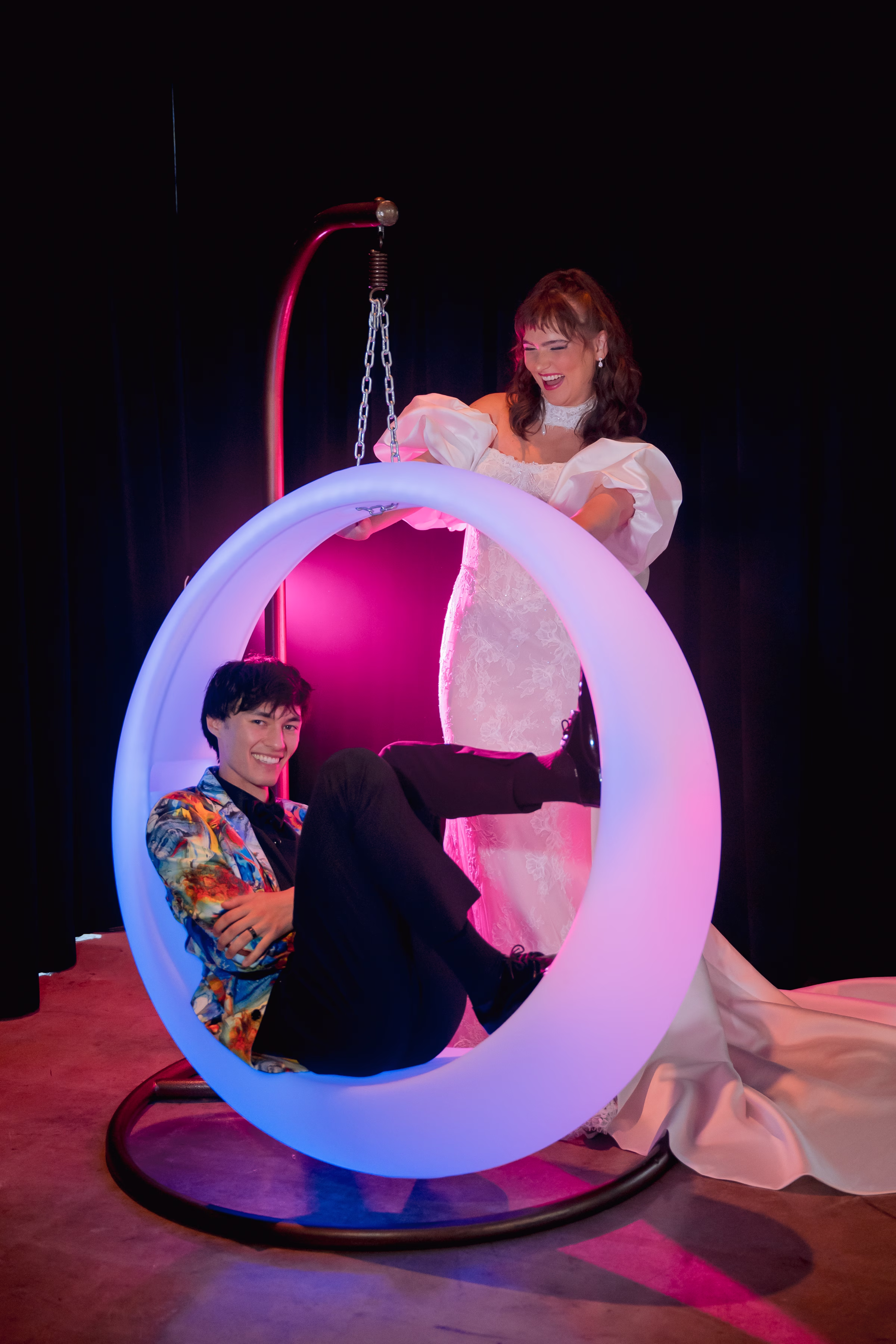 bride and groom models pose with an LED ring-shaped swing set from Record-A-Hit Entertainment