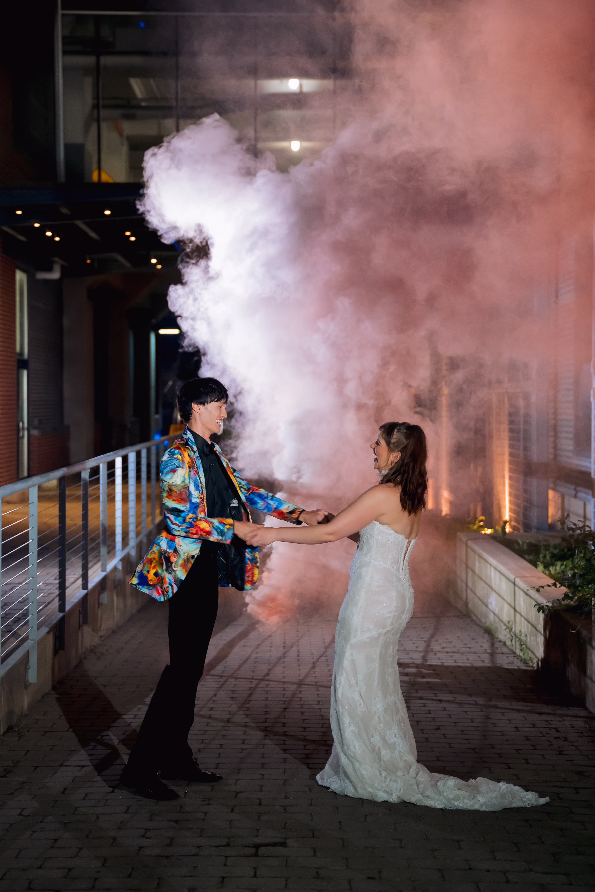 a bride and groom dance as smoke bombs go off behind them at Jan Serr Studio in Milwaukee
