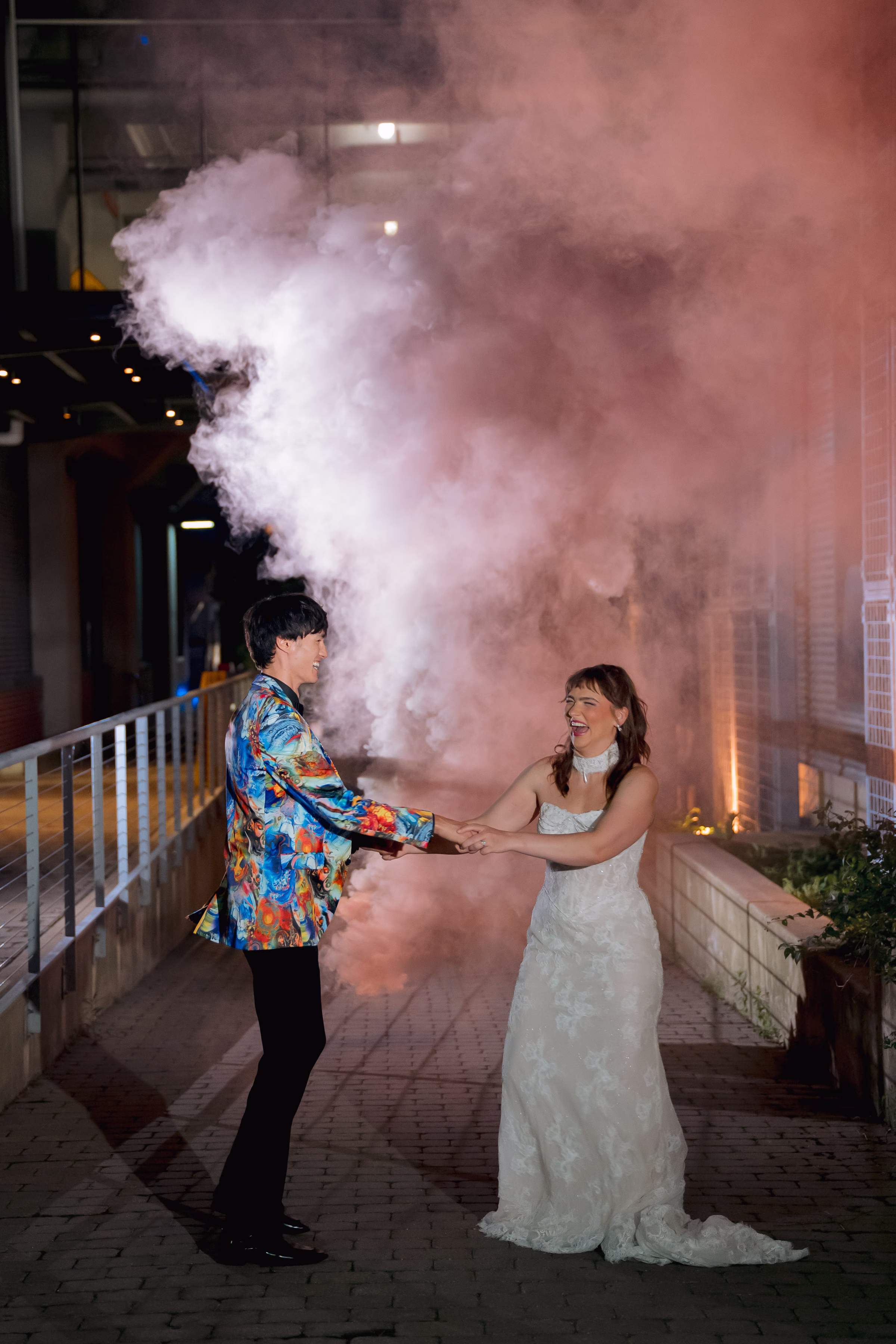 a bride and groom smile and dance as smoke bombs go off behind them at Jan Serr Studio in Milwaukee