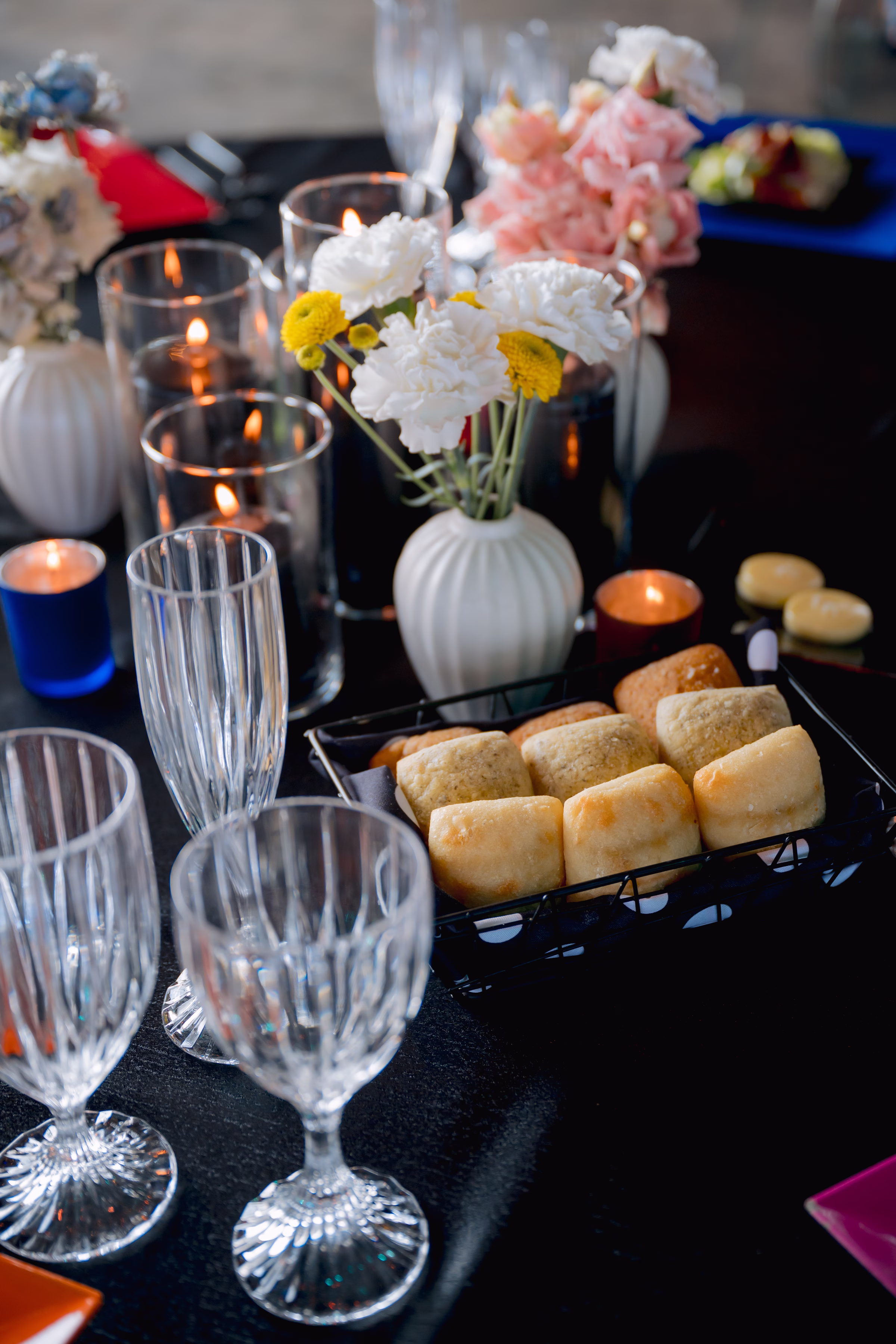 a detail photo sowing crystal glassware, reception floral centerpieces, and dinner rolls from Saz's Catering