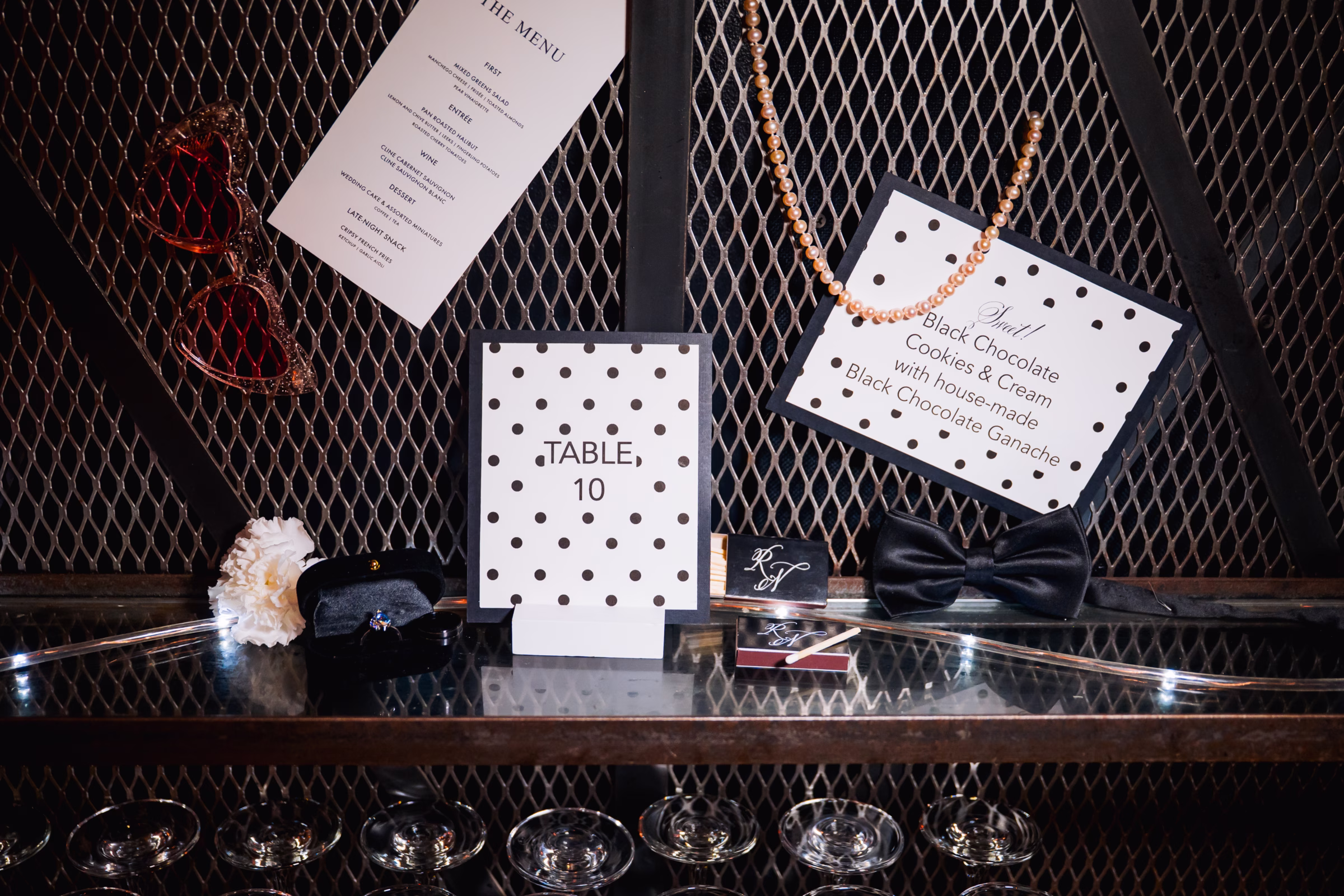 black-and-white polka dot printed reception pieces including a menu, dessert menu, table number, and custom matchbooks from Paper Envy, LLC