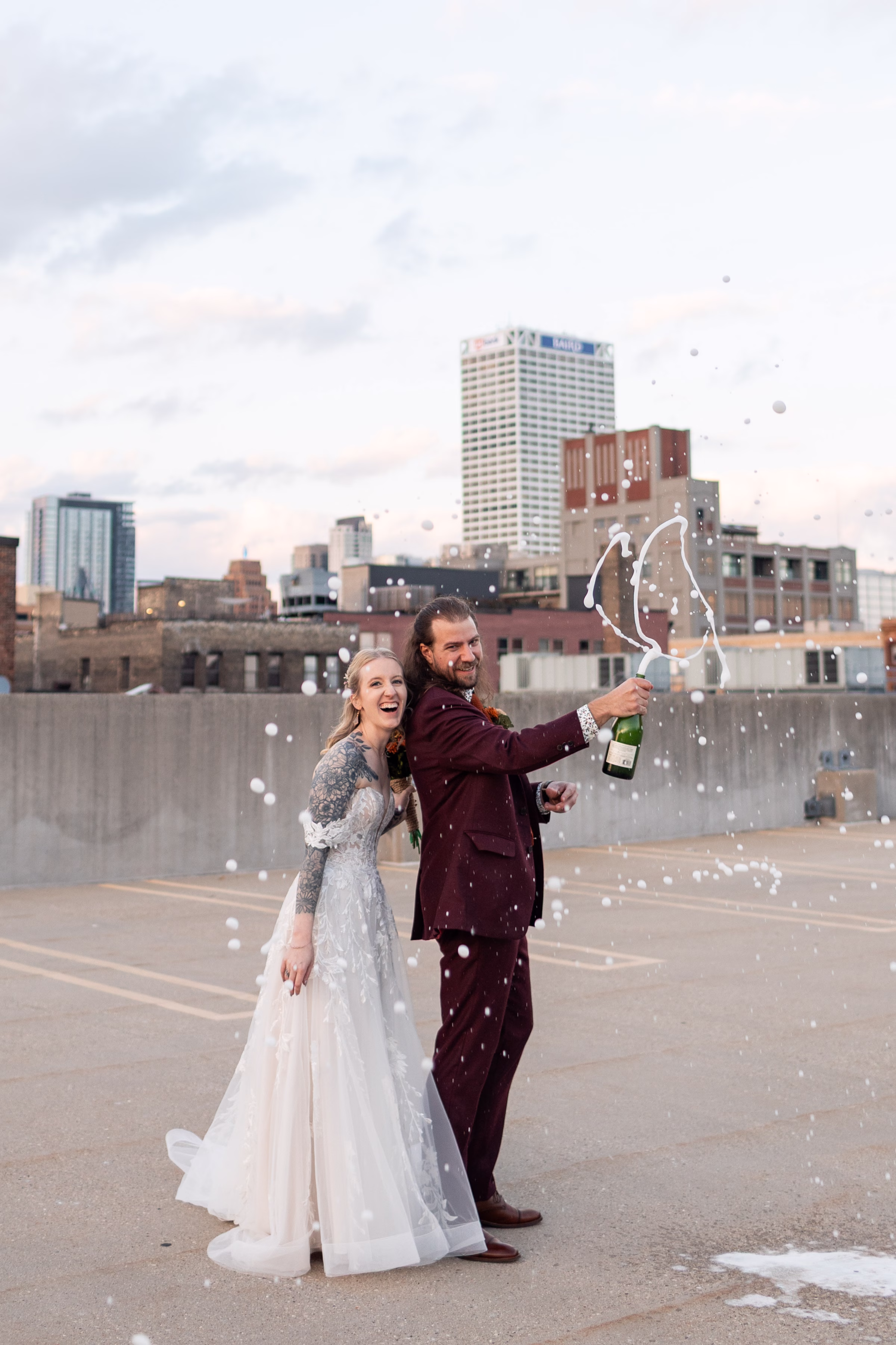 moody romantic fall wedding loft on broadway milwaukee couple portraits 626 11360 - A Moody, Romantic Fall Wedding at The Loft on Broadway | Sarah + Nathan a newlywed couple pops champagne on the top level of a parking garage in Milwaukee, Wisconsin