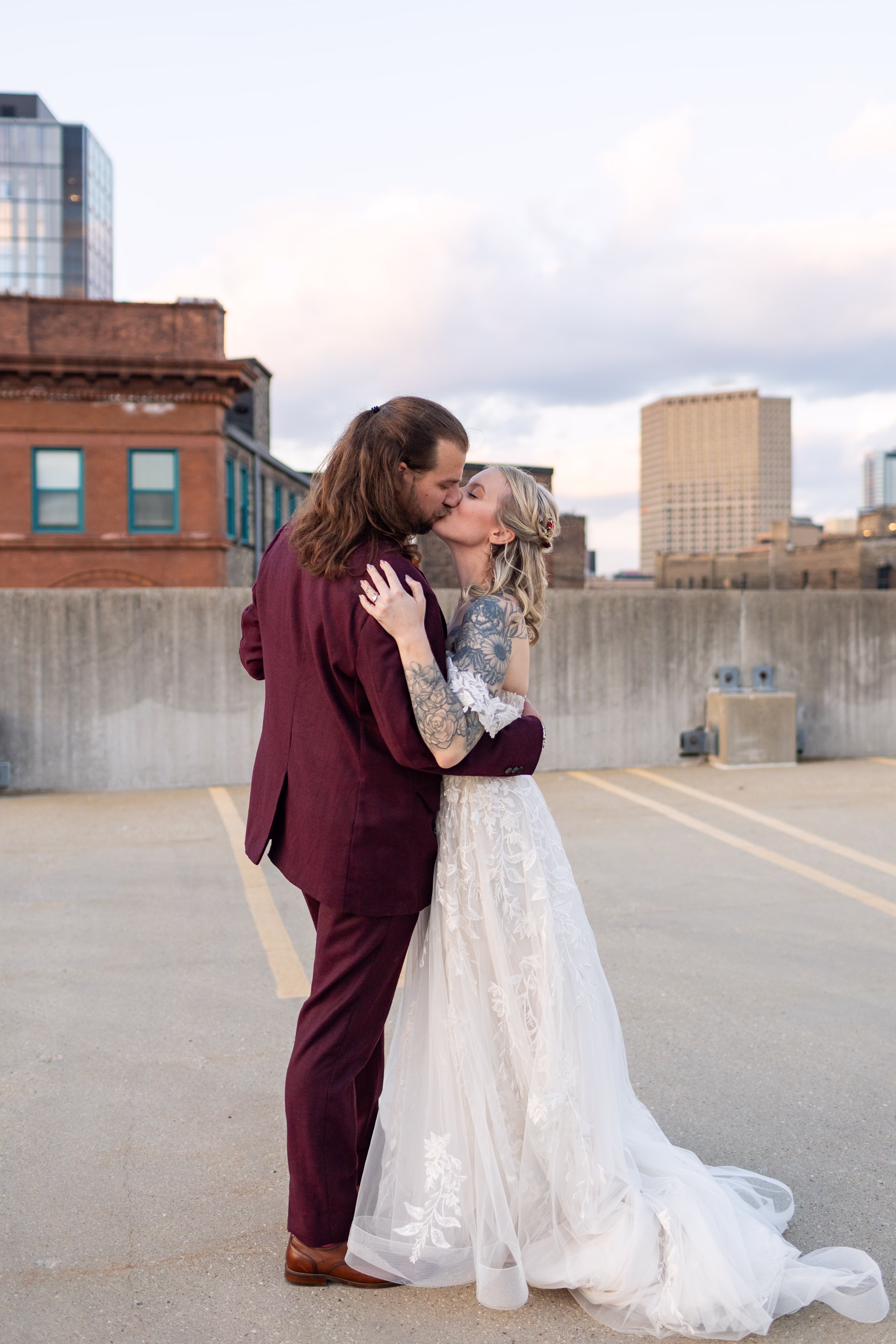moody romantic fall wedding loft on broadway milwaukee couple portraits 648 11482 - A Moody, Romantic Fall Wedding at The Loft on Broadway | Sarah + Nathan a bride and groom kiss in a sunset photo showing the Milwaukee skyline behind them