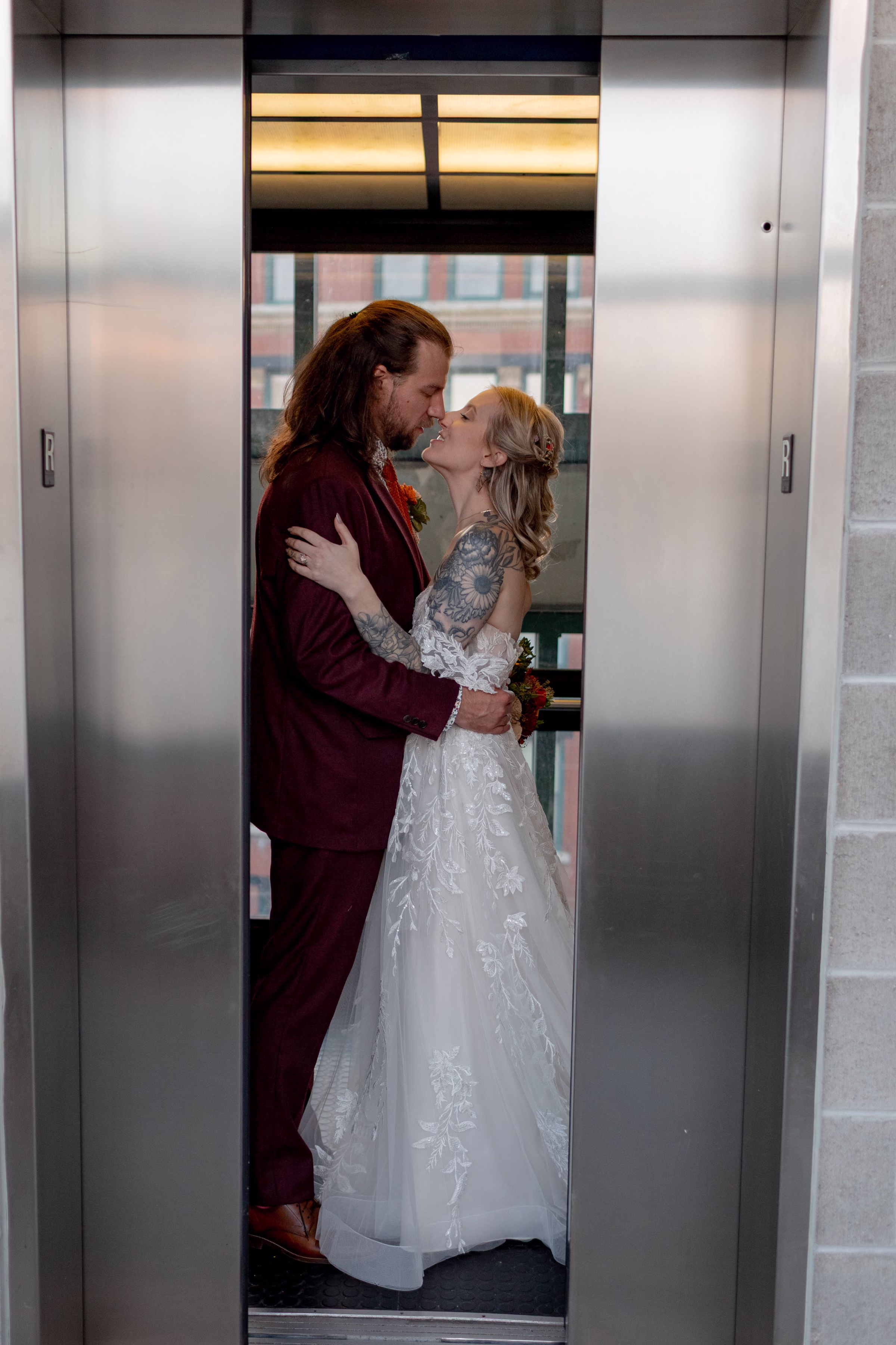 moody romantic fall wedding loft on broadway milwaukee couple portraits 650 11496 - A Moody, Romantic Fall Wedding at The Loft on Broadway | Sarah + Nathan a bride and groom embrace for a romantic photo, nearly sharing a kiss as an elevator door closes