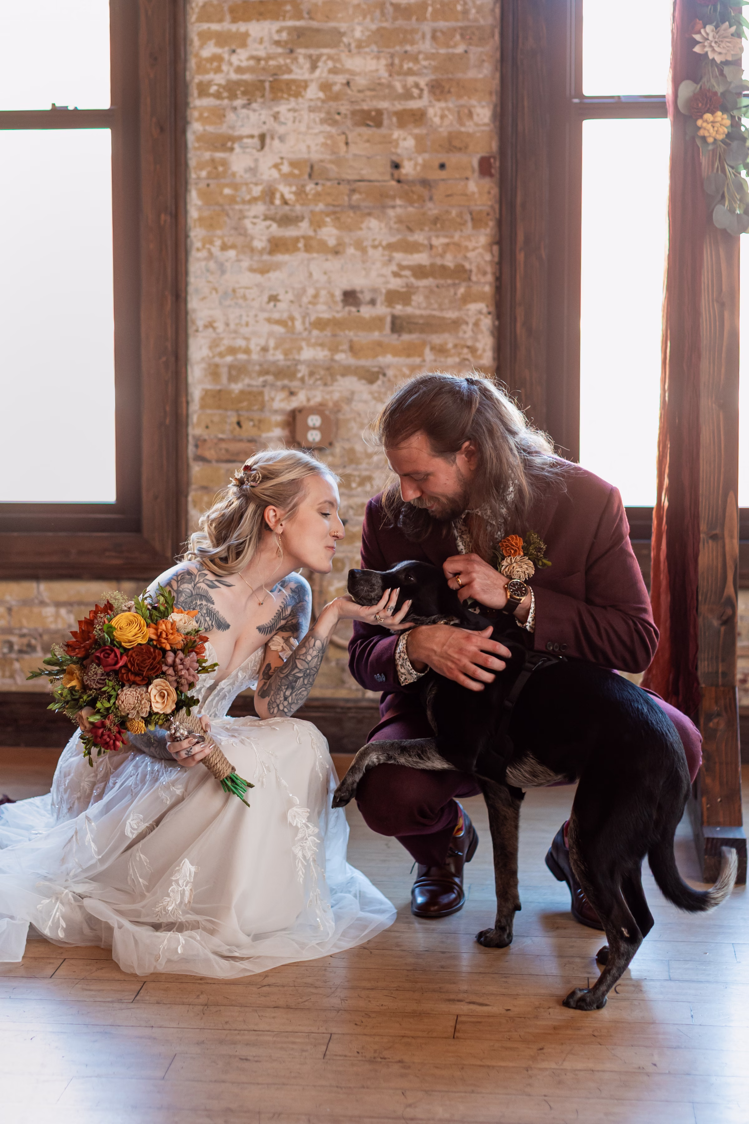 moody romantic fall wedding loft on broadway milwaukee group pet dog 481 0915 - A Moody, Romantic Fall Wedding at The Loft on Broadway | Sarah + Nathan a bride and groom embrace their dog, who has joined them on their wedding day