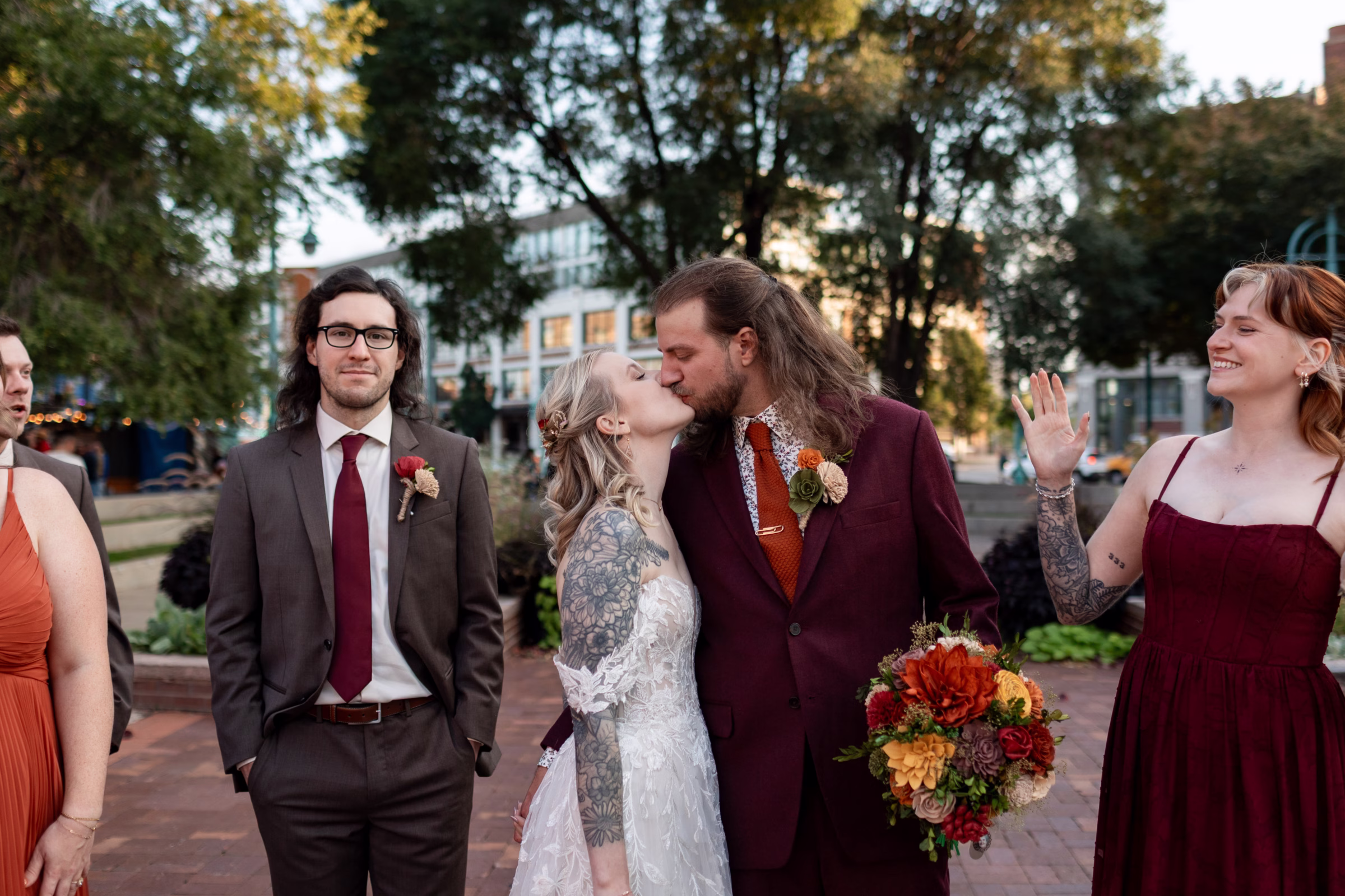 moody romantic fall wedding loft on broadway milwaukee group portraits 538 11078 - A Moody, Romantic Fall Wedding at The Loft on Broadway | Sarah + Nathan a bride and groom share a kiss while their wedding party cheers them on in downtown Milwaukee