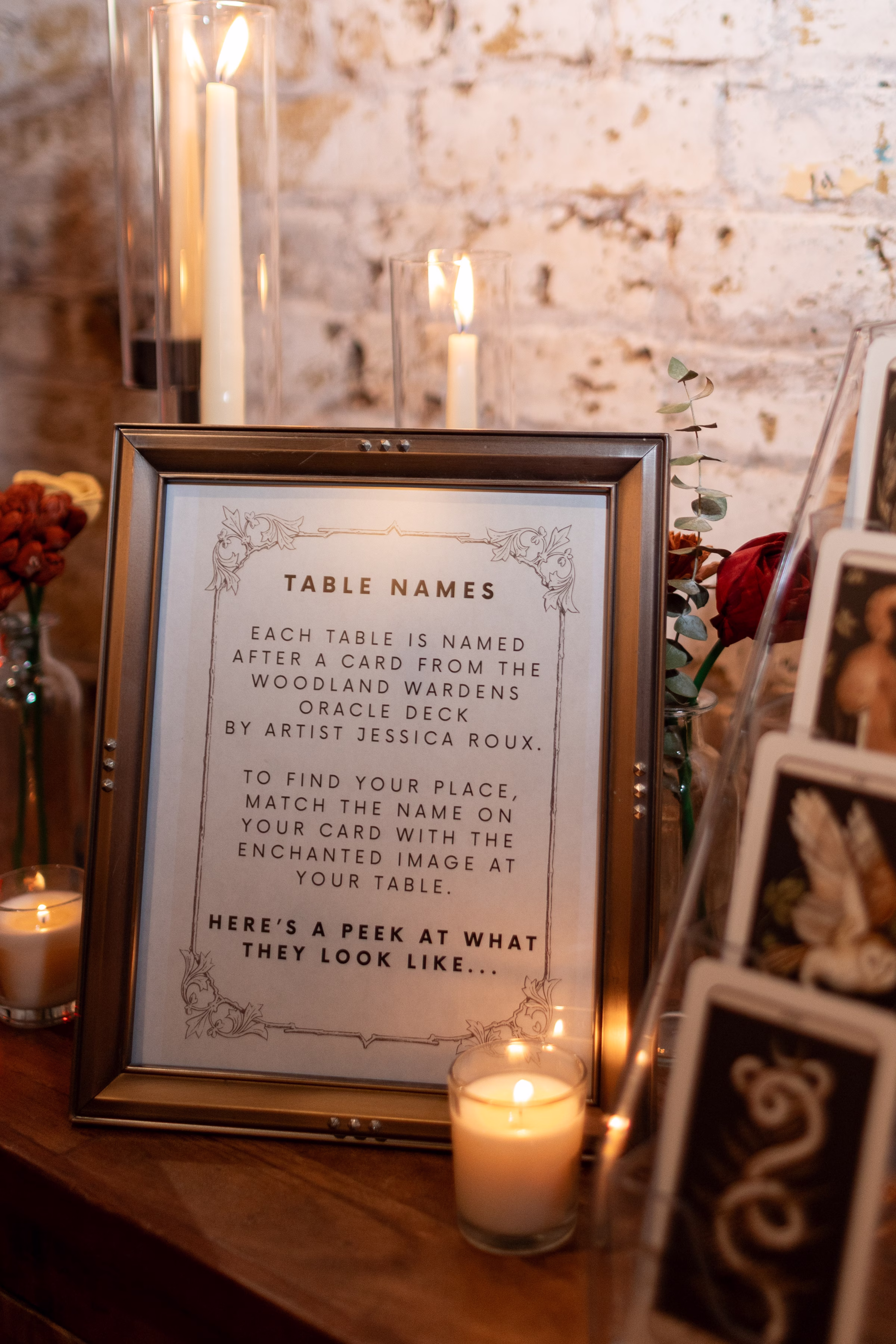 moody romantic fall wedding loft on broadway milwaukee reception signage 394 0666 - A Moody, Romantic Fall Wedding at The Loft on Broadway | Sarah + Nathan wedding signage explaining oracle deck card table names to guests. The sign says, "Table Names. Each table is named after a card from the Woodland Wardens Oracle Deck by artist Jessica Roux. To find your place, match the name on your card with the enchanted image at your table. Here's a peek at what they look like."