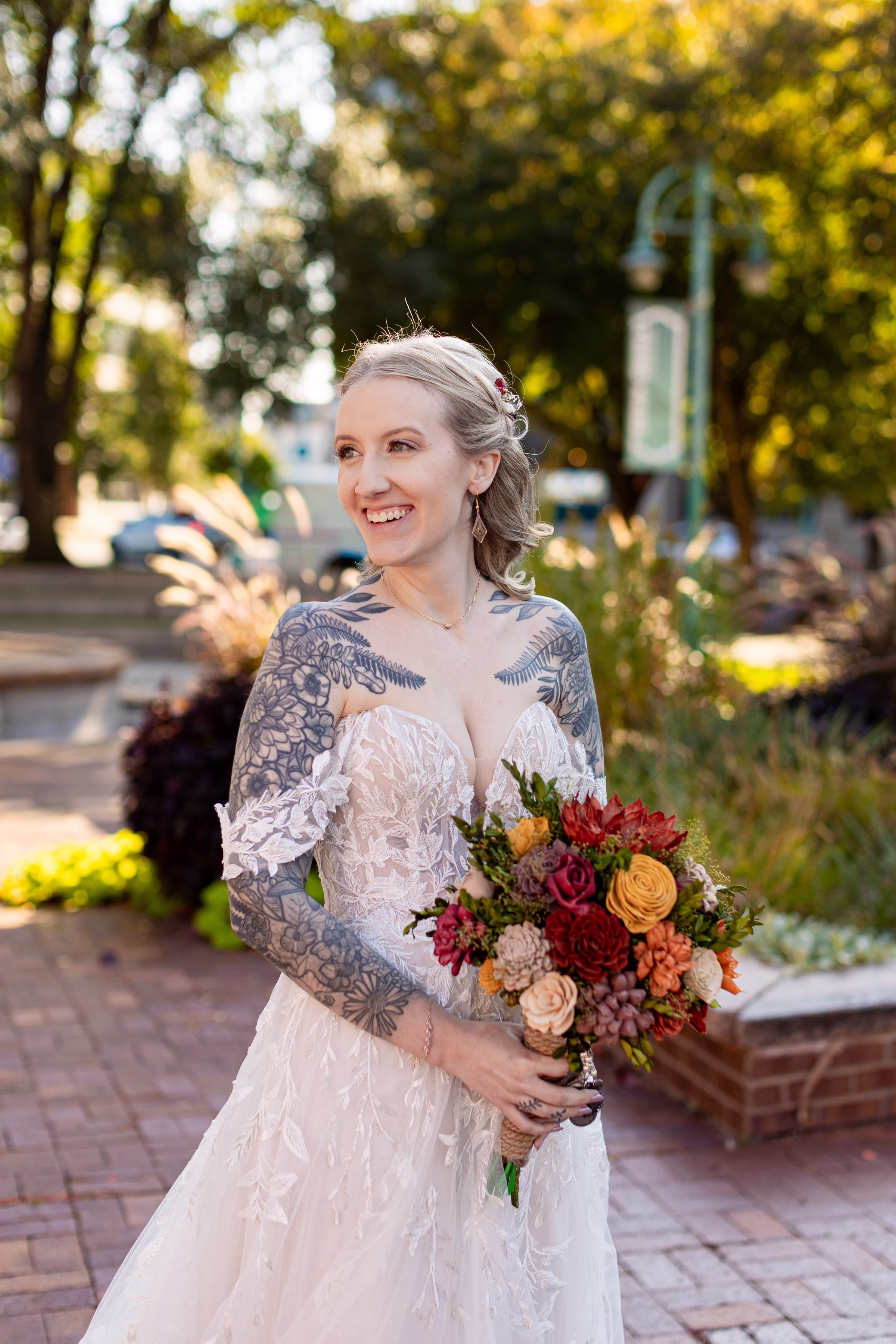 moody romantic fall wedding loft on broadway milwaukee wisconsin bridesmaids portraits 205 10410 - A Moody, Romantic Fall Wedding at The Loft on Broadway | Sarah + Nathan a bride wearing a delicate lace dress from Strike Bridal Bar smiles into the distance while holding a fall-colored bouquet or reds, oranges, blush, yellow, purple, and green