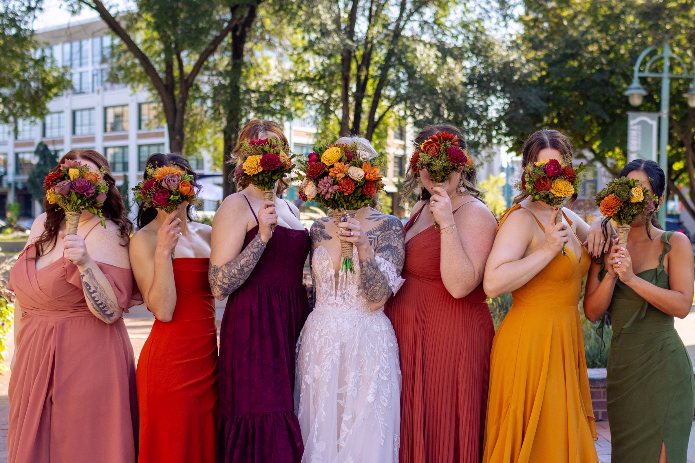 moody romantic fall wedding loft on broadway milwaukee wisconsin bridesmaids portraits 221 0443 - A Moody, Romantic Fall Wedding at The Loft on Broadway | Sarah + Nathan a bride and her bridesmaids hold Sola Wood Flowers bouquets in fall colors in front of their faces