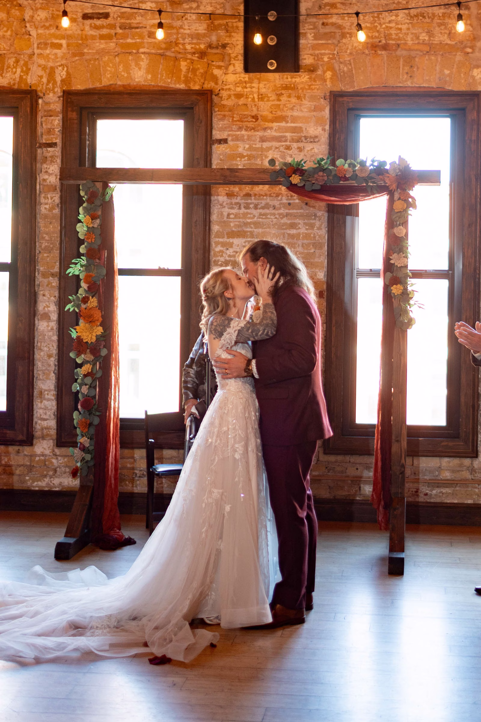 moody romantic fall wedding loft on broadway milwaukee wisconsin ceremony 462 10884 - A Moody, Romantic Fall Wedding at The Loft on Broadway | Sarah + Nathan a bride and groom share a first kiss at their wedding ceremony at The Loft on Broadway