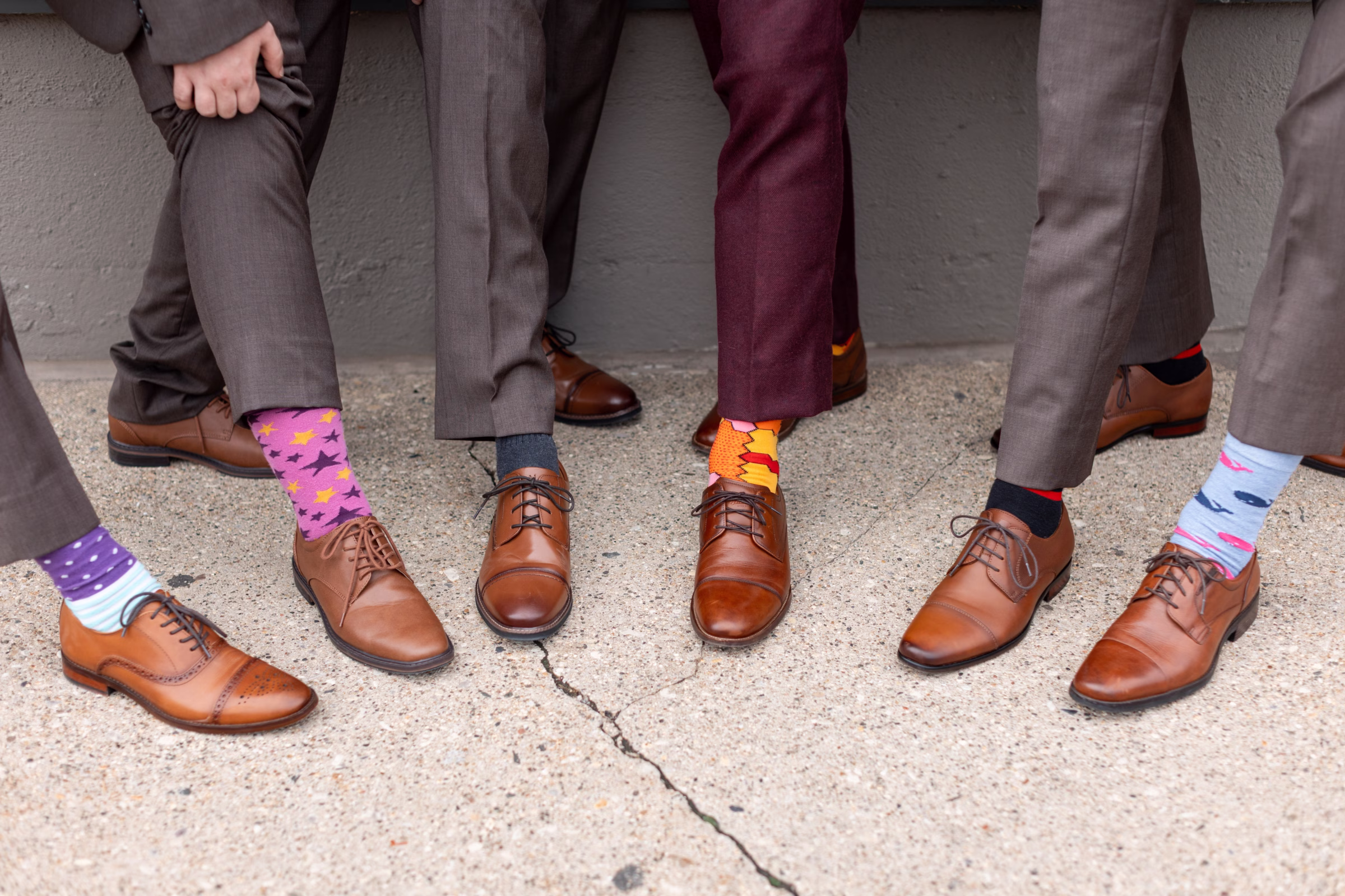 moody romantic fall wedding loft on broadway milwaukee wisconsin groomsmen 108 10312 - A Moody, Romantic Fall Wedding at The Loft on Broadway | Sarah + Nathan a groom and his groomsmen pull up their pant legs to reveal colorful and patterned socks