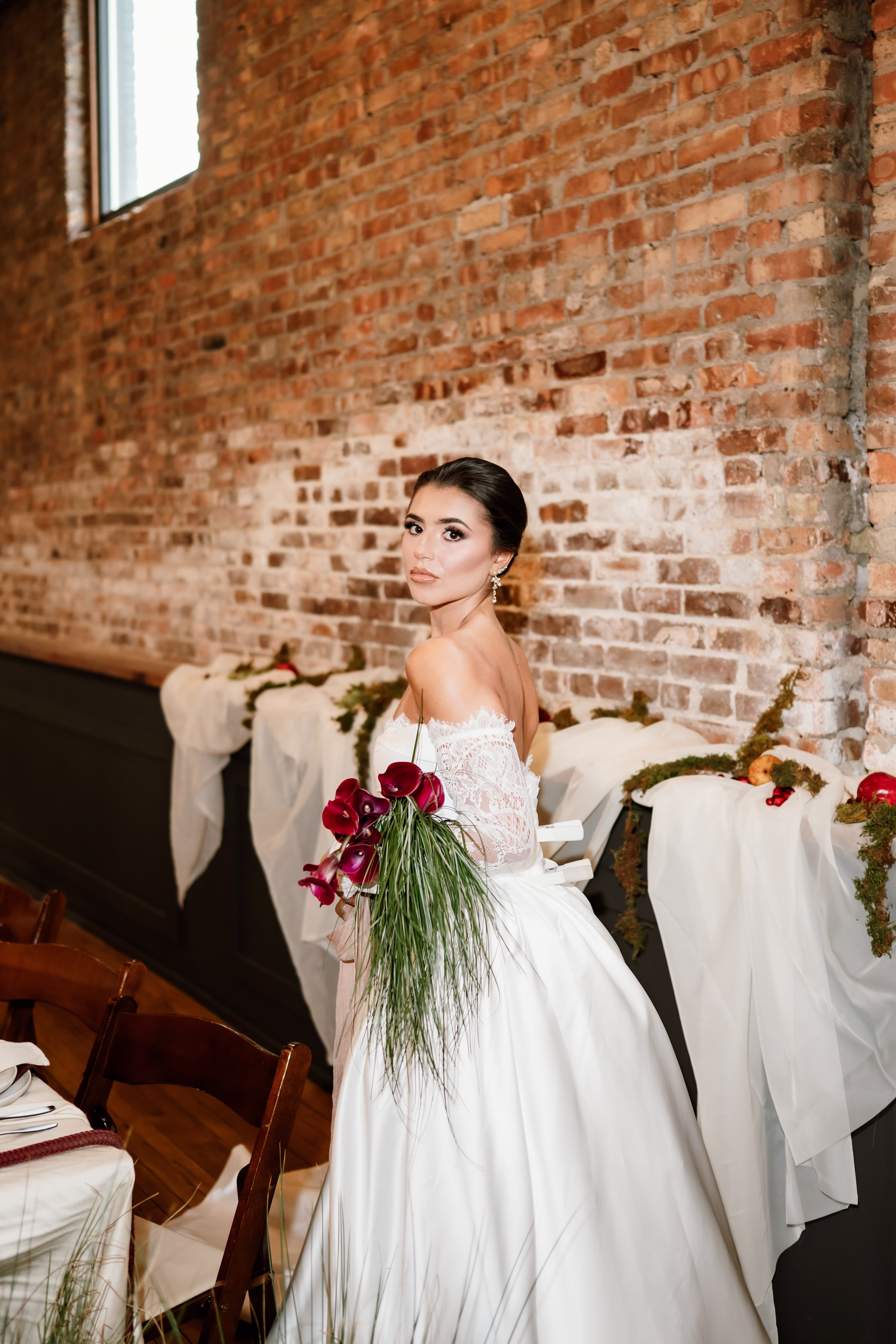 rich velvet fall wedding inspiration mercantile hall burlington wisconsin tablescape bride florals 55 - Rich Velvet Fall Wedding Inspiration at Mercantile Hall in Burlington, Wisconsin a bride holds a bouquet of calla lilies with cascading bear grass. She is waering dramatic eye makeup from NK Artistry LLC, with dark blush and a natural lip