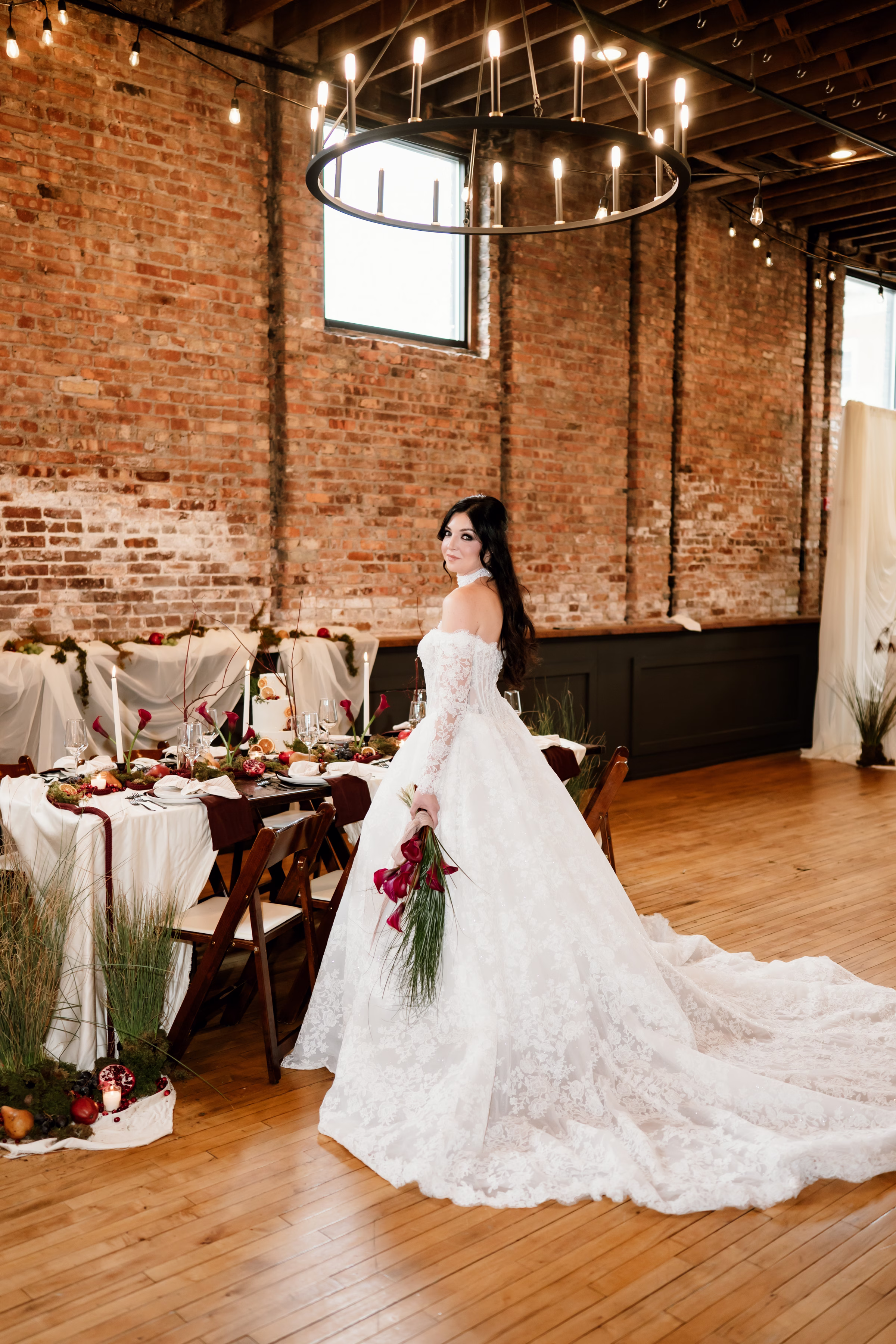 rich velvet fall wedding inspiration mercantile hall burlington wisconsin tablescape bride florals 81 - Rich Velvet Fall Wedding Inspiration at Mercantile Hall in Burlington, Wisconsin a bride stands at a tablescape, showing off a flowing, voluminous lace skirt and cathedral-length train from Bon Bon Belle Bridal Boutique