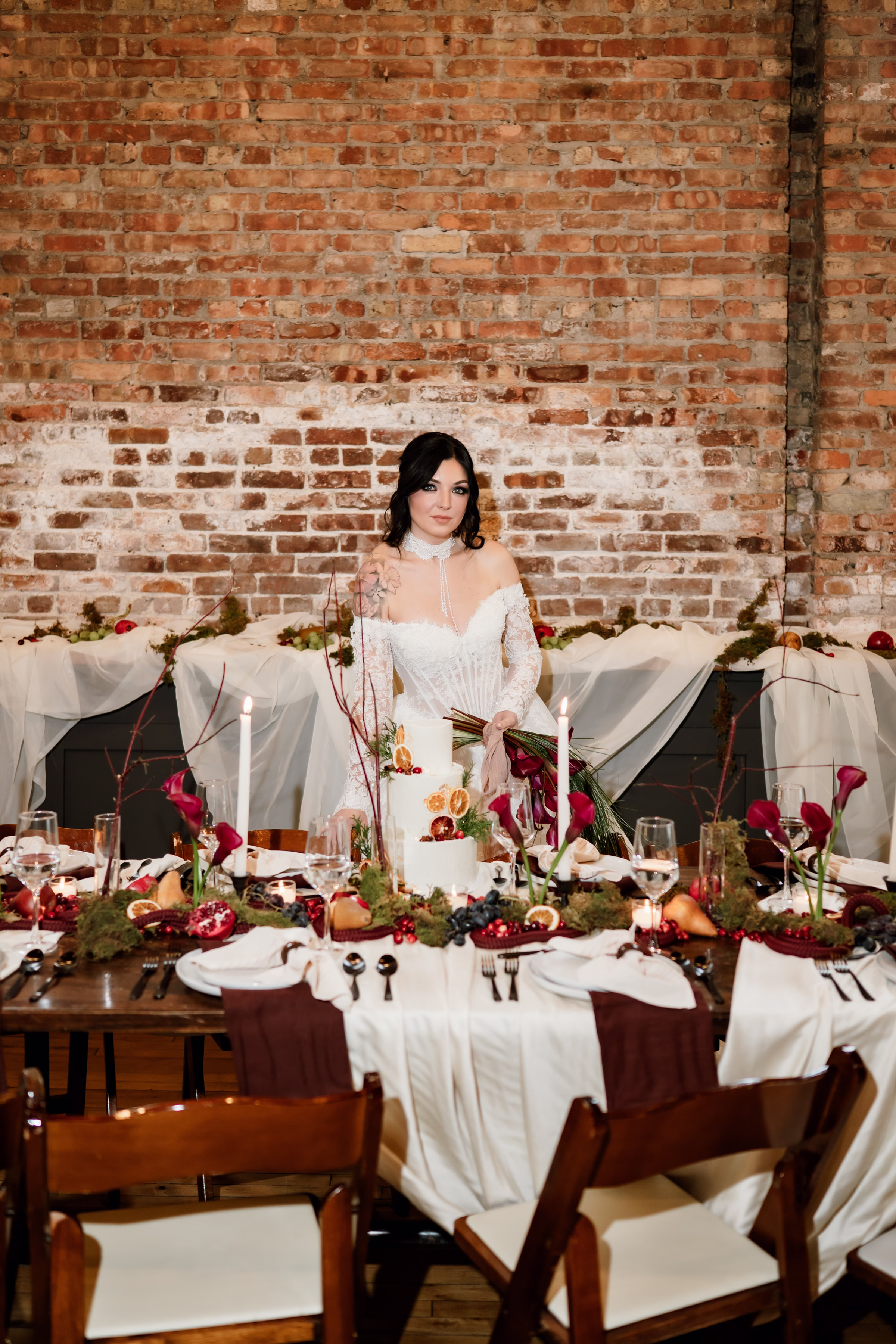 rich velvet fall wedding inspiration mercantile hall burlington wisconsin tablescape bride florals 87 - Rich Velvet Fall Wedding Inspiration at Mercantile Hall in Burlington, Wisconsin a bride stands at a fall wedding reception table set against the natural brick backdrop at Mercantile Hall