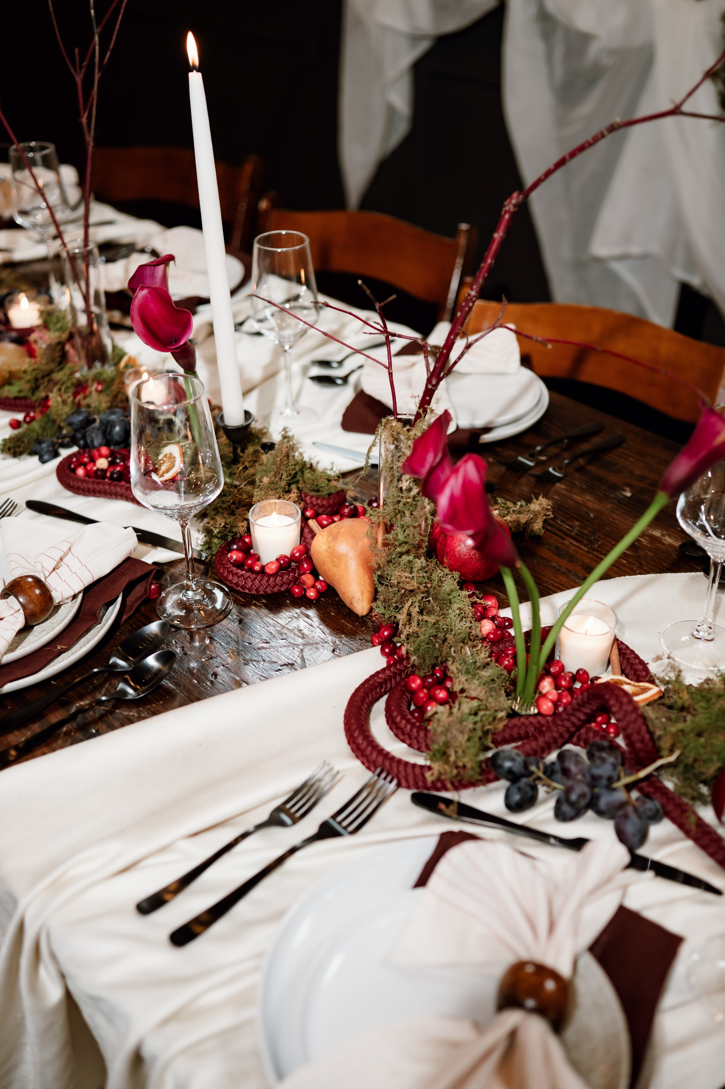 rich velvet fall wedding inspiration mercantile hall burlington wisconsin tablescape decor florals 25 - Rich Velvet Fall Wedding Inspiration at Mercantile Hall in Burlington, Wisconsin a details photo of a fall wedding tablescape highlighting fruit as décor paired with mossy greenery to make an artistic centerpiece